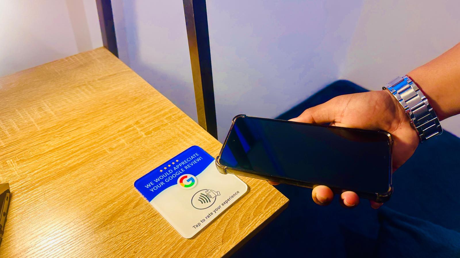 Customer tapping phone on ReviewBoost NFC card